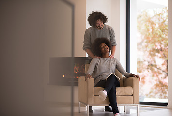 Image showing multiethnic couple hugging in front of fireplace