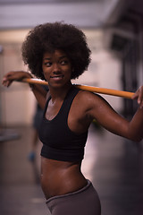 Image showing black woman lifting empty bar