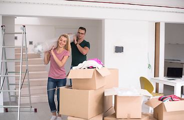 Image showing couple carrying a carpet moving in to new home