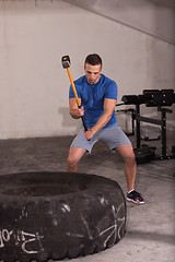 Image showing man workout with hammer and tractor tire