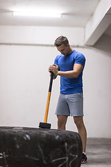 Image showing man workout with hammer and tractor tire