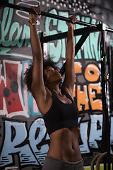 Image showing black woman doing pull ups