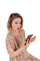 Image showing Surprised woman looking at her cellphone.
