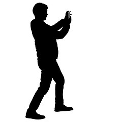 Image showing Silhouettes man taking selfie with smartphone on white background