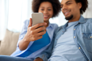 Image showing happy couple with smartphones at home