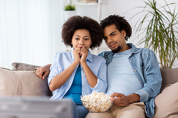 Image showing happy couple with popcorn watching tv at home