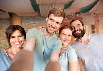 Image showing happy friends at yoga studio or gym taking selfie