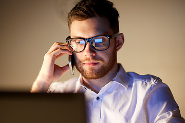 Image showing businessman calling on smartphone at night office