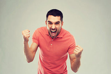 Image showing happy man celebrating victory over gray background