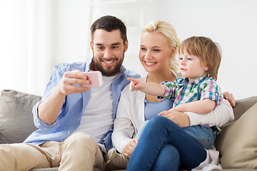 Image showing happy family with smartphone at home