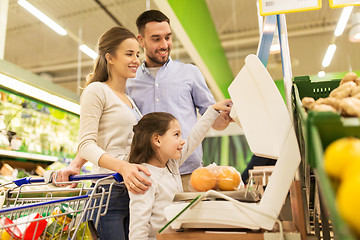 Image showing family weighing oranges on scale at grocery store