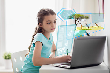 Image showing girl with laptop writing to notebook at home