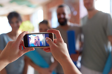 Image showing photo of people at yoga studio on smartphone