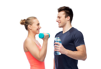 Image showing sportive man and woman with dumbbell and water