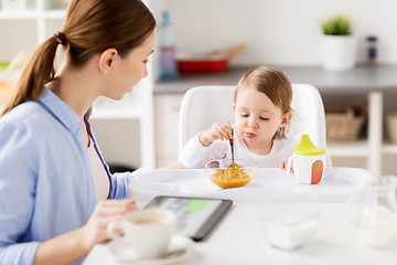 Image showing happy mother and baby having breakfast at home