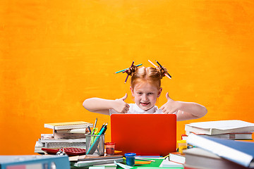 Image showing The Redhead teen girl with lot of books at home. Studio shot