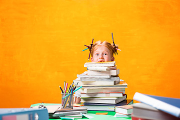 Image showing The Redhead teen girl with lot of books at home. Studio shot