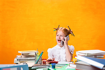 Image showing The Redhead teen girl with lot of books at home. Studio shot