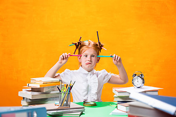 Image showing The Redhead teen girl with lot of books at home. Studio shot