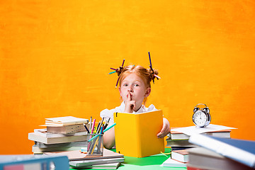 Image showing The Redhead teen girl with lot of books at home. Studio shot