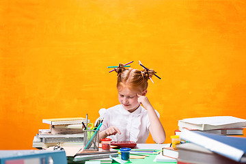 Image showing The Redhead teen girl with lot of books at home. Studio shot