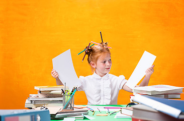 Image showing The Redhead teen girl with lot of books at home. Studio shot