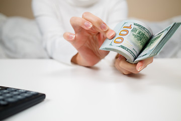 Image showing business, finance, saving, banking and people concept - close up of woman hands counting us dollar money