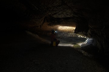 Image showing Woman with headlamp inside cave