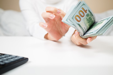 Image showing business, finance, saving, banking and people concept - close up of woman hands counting us dollar money