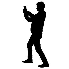 Image showing Silhouettes man taking selfie with smartphone on white background