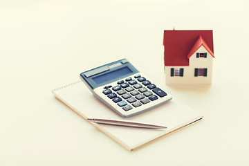 Image showing close up of home model, calculator and notebook