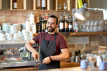 Image showing barista with holder and tamper making at coffee