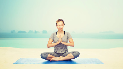 Image showing woman making yoga meditation in lotus pose on mat