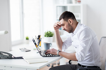 Image showing stressed businessman with laptop at office