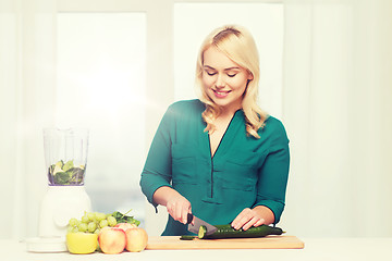 Image showing smiling woman with blender cooking food at home