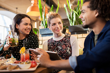 Image showing happy friends eating and drinking at restaurant