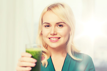 Image showing smiling woman drinking juice or smoothie at home