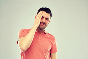 Image showing unhappy man suffering from head ache