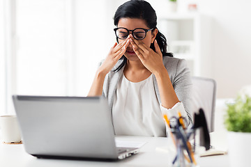 Image showing businesswoman rubbing tired eyes at office