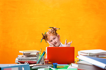 Image showing The Redhead teen girl with lot of books at home. Studio shot