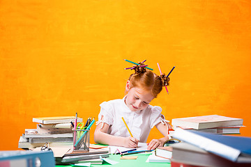 Image showing The Redhead teen girl with lot of books at home. Studio shot