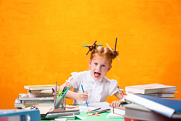 Image showing The Redhead teen girl with lot of books at home. Studio shot