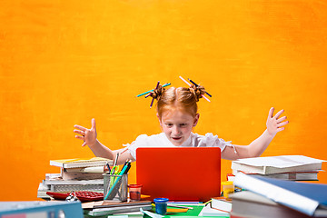 Image showing The Redhead teen girl with lot of books at home. Studio shot