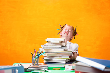 Image showing The Redhead teen girl with lot of books at home. Studio shot