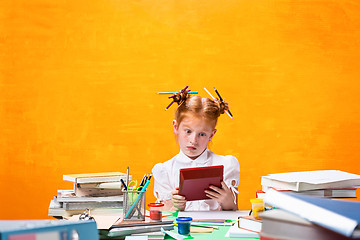 Image showing The Redhead teen girl with lot of books at home. Studio shot
