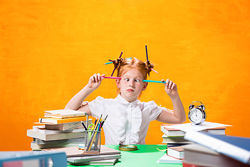 Image showing The Redhead teen girl with lot of books at home. Studio shot