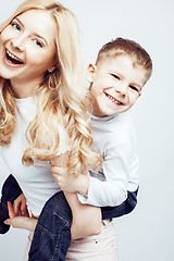 Image showing young modern blond curly mother with cute son together happy smiling family posing cheerful on white background, lifestyle people concept, sister and brother friends