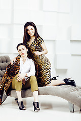 Image showing pretty stylish woman in fashion dress with leopard print together in luxury rich room interior, lifestyle people concept, modern brunette together