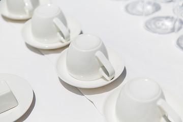 Image showing white coffee cups upside down on saucers