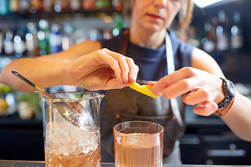 Image showing bartender with glass of cocktail and lemon at bar